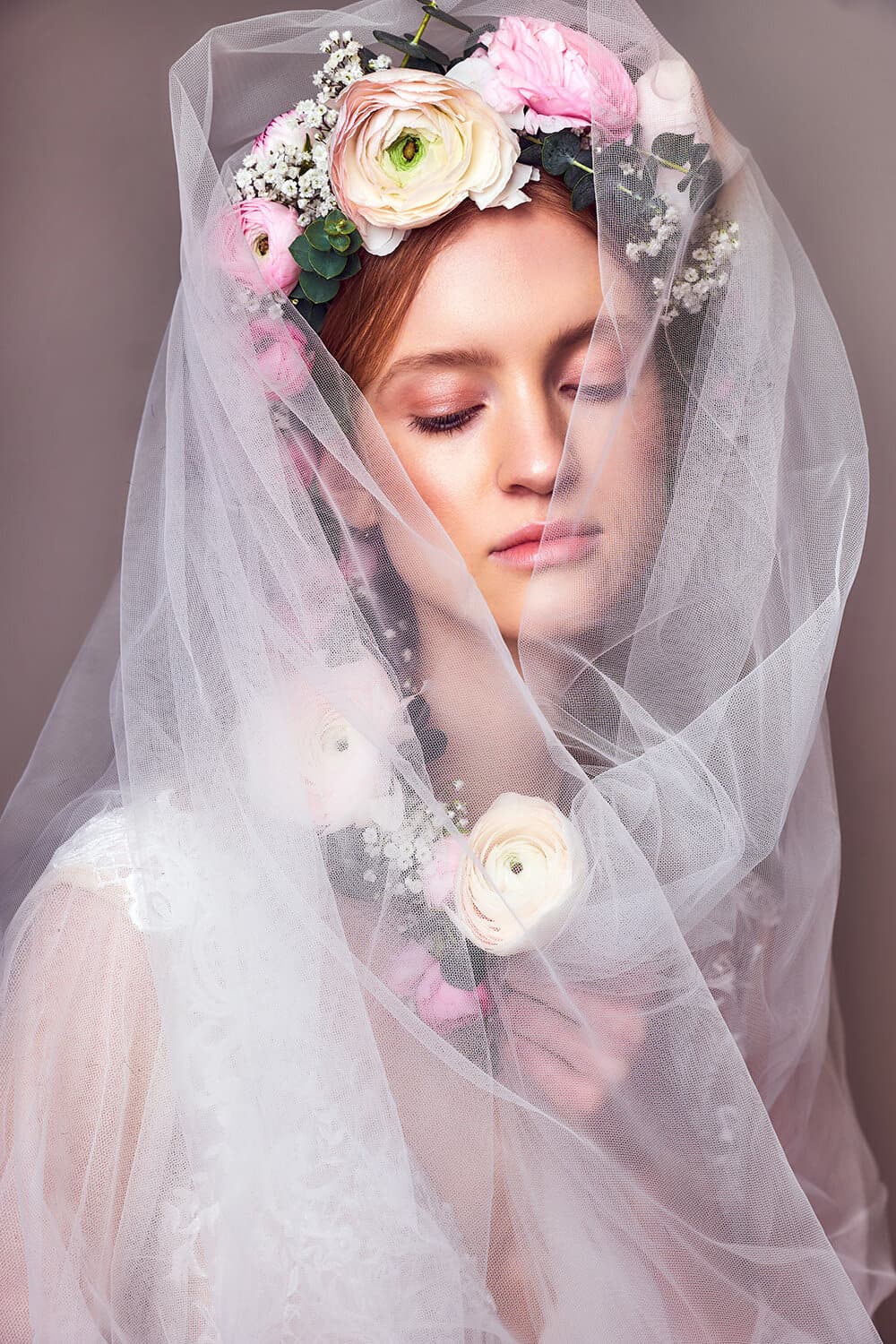 Braut mit Schleier, der mit Blüten verziert ist.