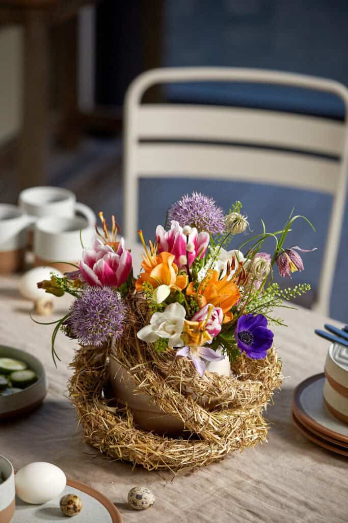 Bouquet aus Tulpen, Ranunkeln, Zierlauch, Anemonen, Freesien und Co. wird durch eine Heugirlande akzentuiert.