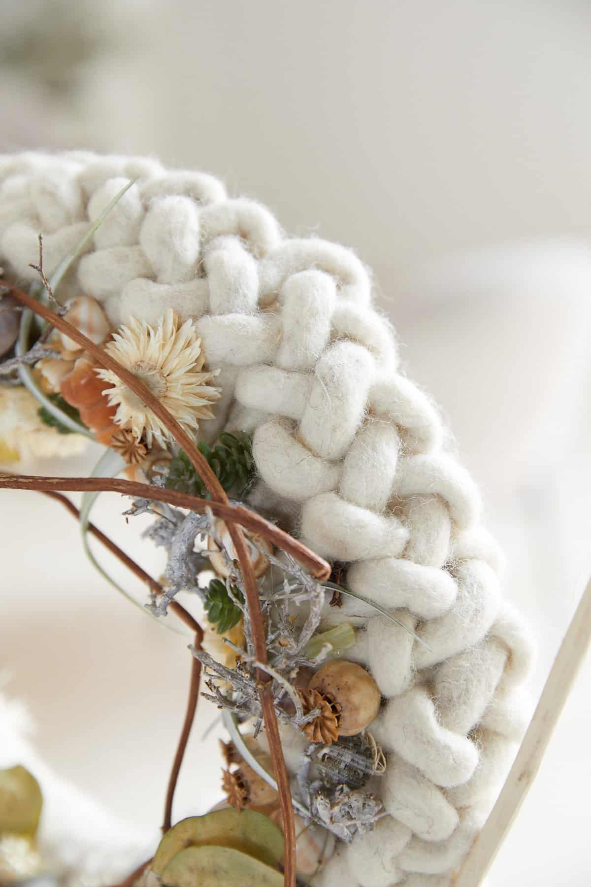 Geflochtener Kranz aus Wolle und getrockneten Floralien
